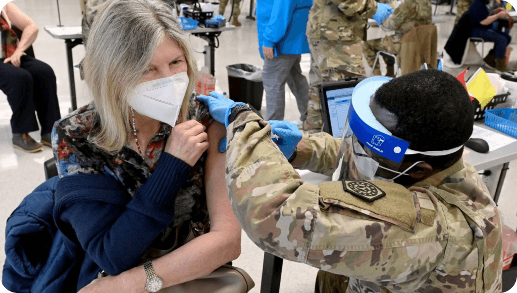 woman wearing a mask receiving a vaccine