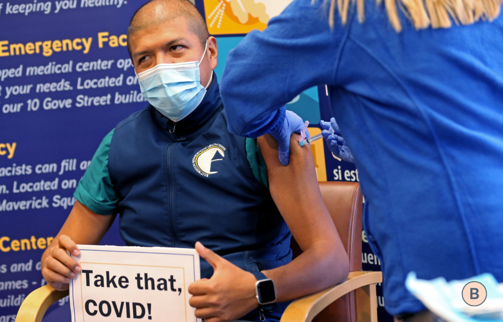 man wearing a mask receiving a vaccine